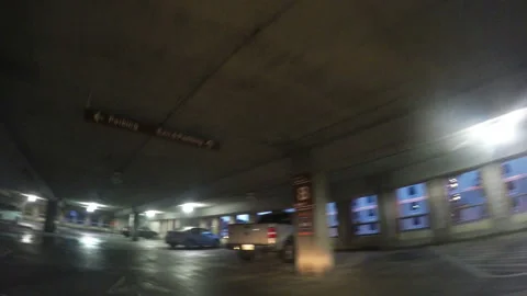 Car driving along a parking deck on a rainy evening Video stock 155768475