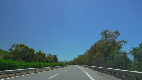 Car driving along a scenic empty highway under a clear blue sky Stock-Footage 346250113