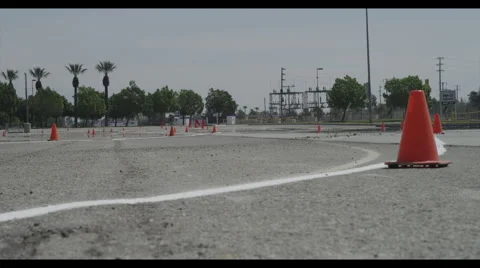Car driving around pylons in test lot Vidéo 56966476
