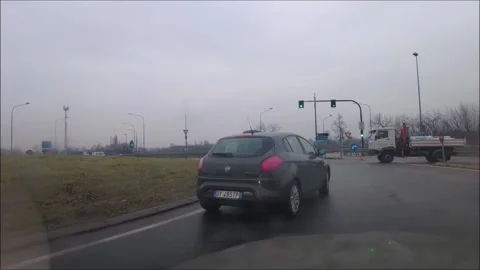 Car driving around a traffic circle and into the parking lot of a shopping mall  Stock Footage 295885486
