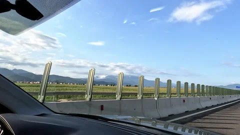Car driving behind soundproof wall on highway Stock Footage 314950374