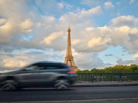 Car driving on bridge with eiffel tower in background under cloudy sky 写真素材