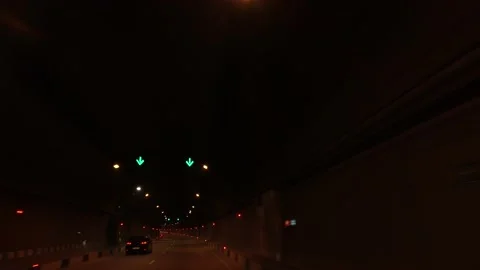 Car driving on city road through dark illuminated tunnel Stock Footage