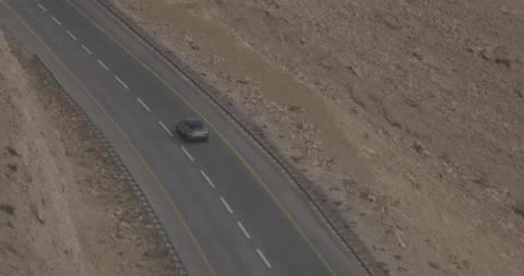 Car Driving on Cliffside Road in Mitzpe Ramon, overlooking Crater, Israel Stock Footage 137102634