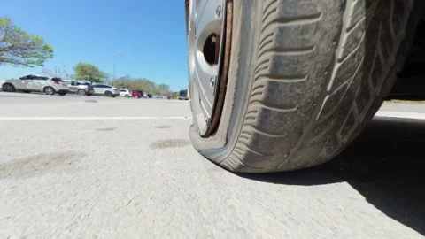 Car driving on a completely flat tire on the asphalt road Stock Footage 334315574