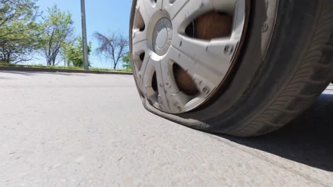 Car driving on a completely flat tire on the asphalt road Stock Footage 334315611