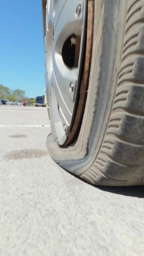Car driving on a completely flat tire on the asphalt road Vidéo 334315634