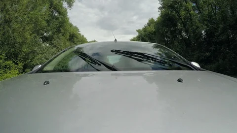 Car driving on the daytime highway, windshield wipers work. Travel in car Stock Footage 99406159