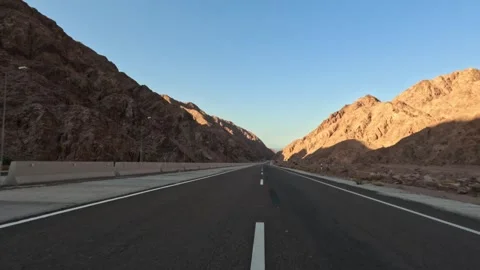 Car driving on desert highway between rocky mountains in the evening Stock Footage 340874485