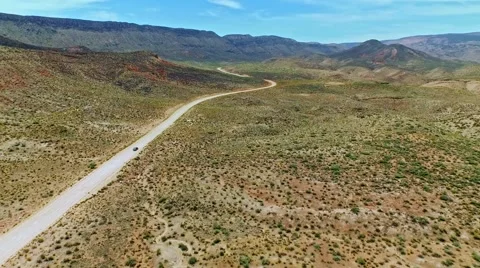 Car driving on a dirt road through iconic, dry Arizona landscape Stock Footage 52808909
