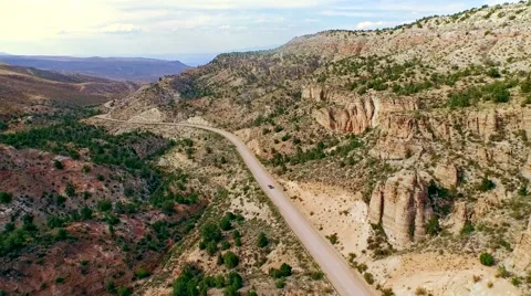 Car driving on a dirt road through iconic, dry Arizona landscape Stock Footage 52810739