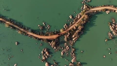 A Car Driving on a Dirt Road Through Flooded Landscape in Botswana Stock Footage 343876518