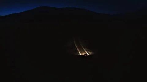 Car driving down dark mountain road at night Foto stock