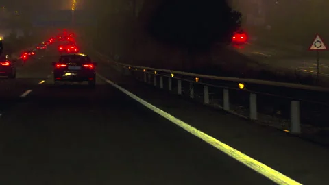 A car is driving down a dark road with a lot of traffic Video stock 326955806