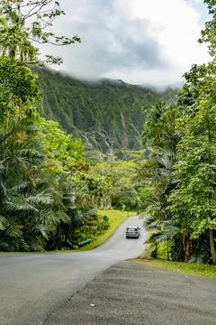 A car driving down an empty road towards the Ko?olau Range in Hawaii Stock Photos