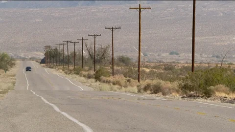 Car driving down hot desert road Vídeo Stock 99211463