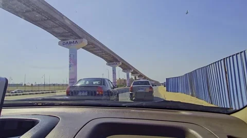 A car driving down a road with a bridge in the background Stock Footage 291553264