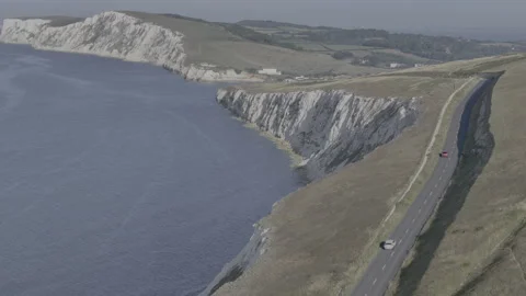 A car is driving down a road that is next to a body of water Stock Footage 298292839