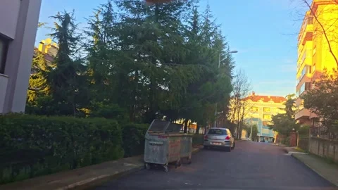 A car driving down a street next to a building Stock Footage 272995996