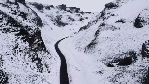 Car Driving Down Through Snowy Mountains Stock Footage 166965823