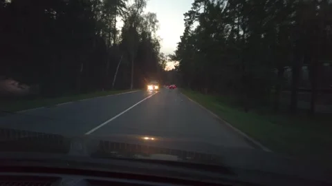 Car Driving At Dusk Down Tree-Lined Road With Headlights On Seen Through Windshi Vídeos de archivo 335448601