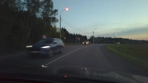 Car Driving At Dusk Down Tree-Lined Road With Headlights On Seen Through Windshi Stock Footage 335448619