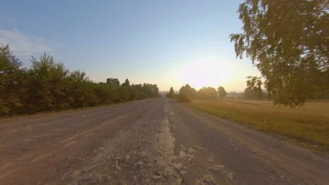 Car driving on dust road through forest and field with dust from opposite car in Stock Footage 143760342