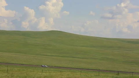 Car driving on an earth road through the grasslands Stock Footage 40490138
