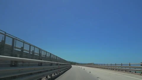 Car driving on elevated highway bridge under blue sky Stock Footage 346250164