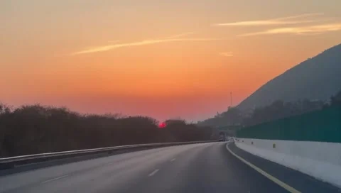Car driving on empty highway at sunset with mountain view Stock Footage 333613357