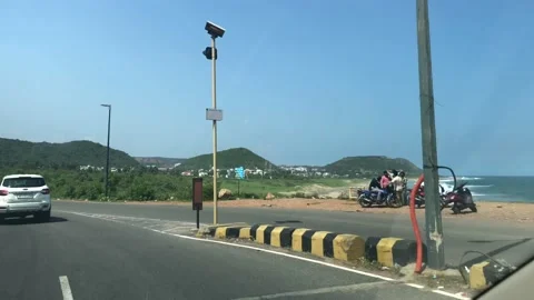 Car driving front view on a hilly road beach side at Vizag Rushikonda Stock Footage 141490980
