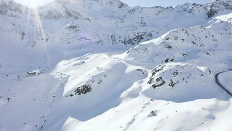 Car driving on mountain road surrounded by snowy Austrian Alps. 4k drone view. Stock Footage 143323805