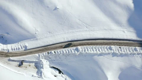 Car driving on mountain road surrounded by snowy Austrian Alps. 4k drone view. Stock Footage 143324082