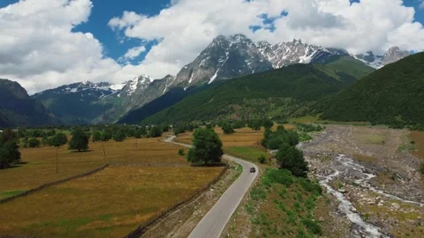 Car driving on mountain road through green valley Stock-Footage 343318649
