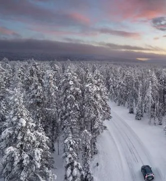 Car Driving on Mountain Road Through Snowy Forest Stock Photos