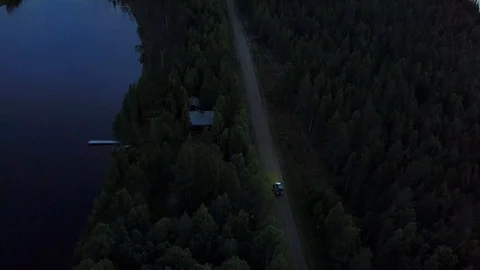 Car driving in night through forest, a lake on the roadside, headlamps Stock-Footage 104650434