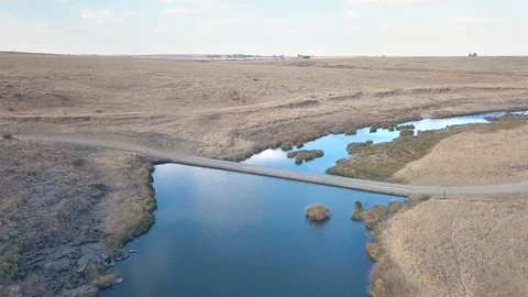Car driving over small bridge in rural setting aerial drone shot Stock Footage 79806633