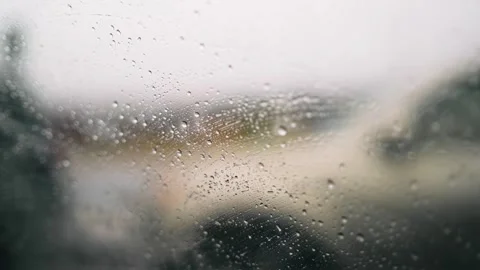 Car driving in the rain in traffic jam. Closeup view of raindrops on side win Stock Footage 325626508