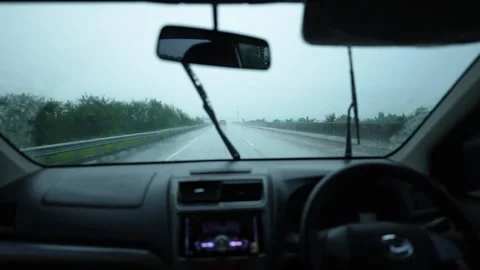 Car driving in the rain with wipers on Stock Footage 258884235