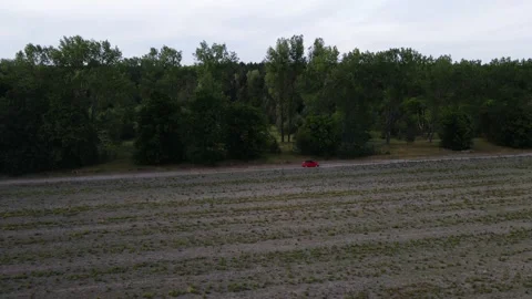 The car is driving on the road in the field. Flying over the car. Stock Footage 233819065