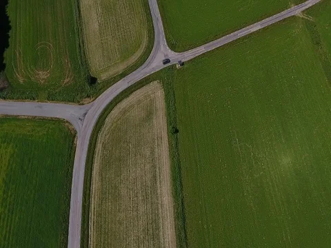 Car driving on a road by a field Stock Footage 77472484