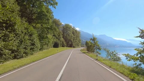 Car driving on the road next to the beautiful blue lake in Interlaken Berner Stock Footage