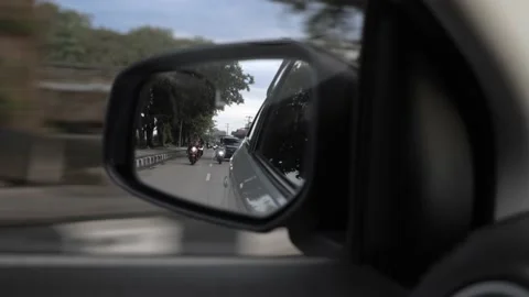 Car driving on the road. Reflection in a car mirror, car speeding on street Stock Footage 146312636