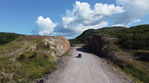The car is driving on the road through the rock aerial shot Stock Footage 181420106