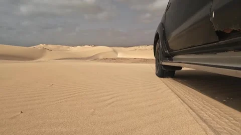 Car driving on sandy desert under cloudy skies in Boa Vista 库存影片 302584520