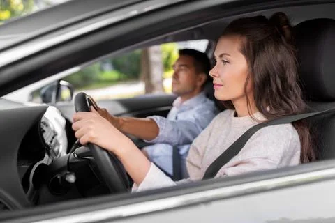 Car driving school instructor teaching woman Stock Photos