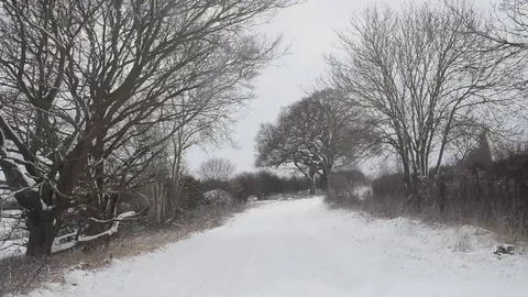 Car driving through blizzard winter conditions on country road uk Stock Footage 89575727