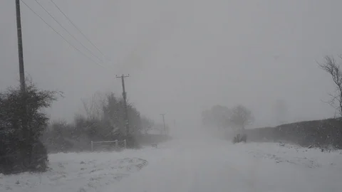 Car driving through blizzard winter conditions on country road uk Stock Footage 89576173