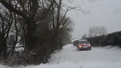 Car driving through blizzard winter conditions on country road uk Stock Footage 89576571