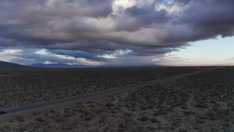 Car driving through dark Mojave Desert before winter storm, AERIAL 스톡 동영상 122004974